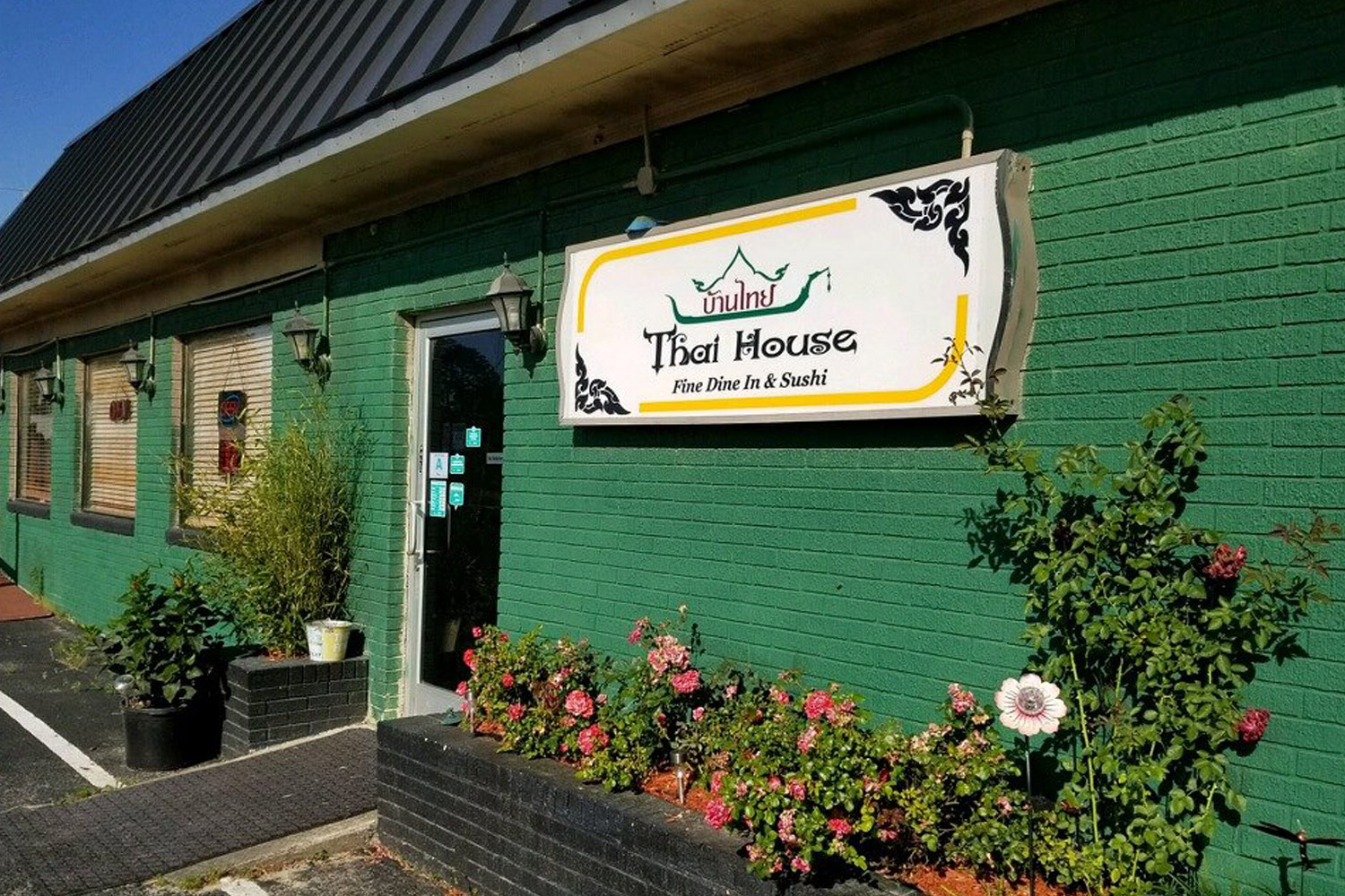 exterior green wall and sign of Thai House in Santee
